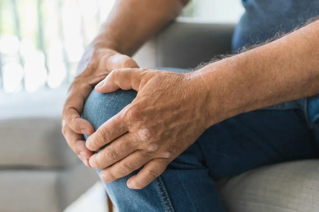 Person hält sich vor Schmerz das Knie